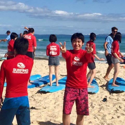 A young surfer smiling for the cameras