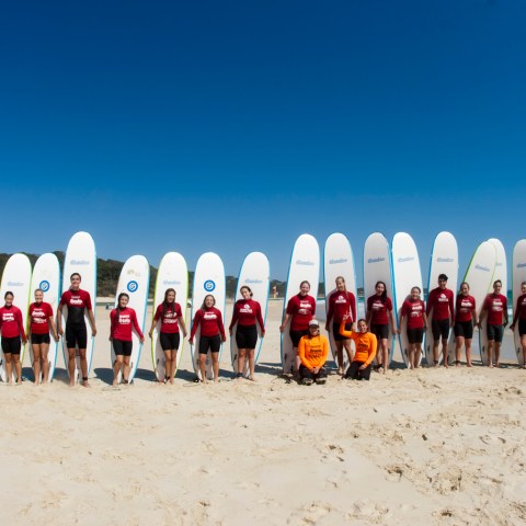 A group of surfers posing with their boards