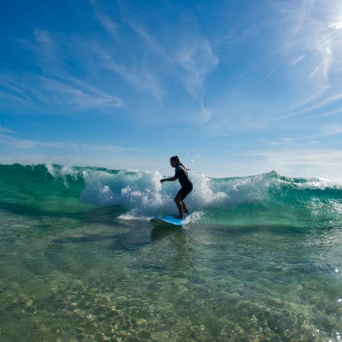 A surfer riding into shore on a wave