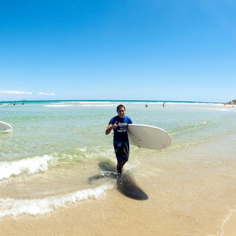 A surfer strutting out of the water