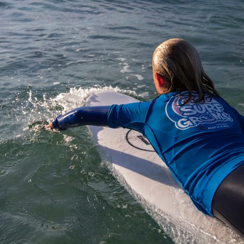 A young surfer getting ready to catch a wave.